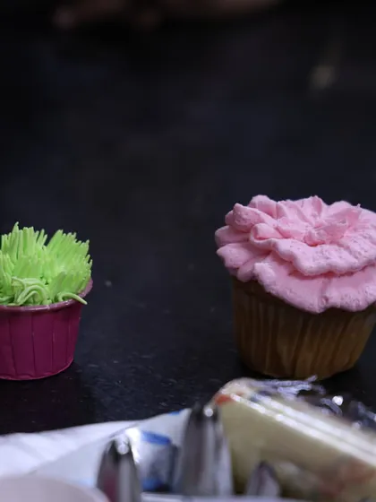 Another shot from my workshop, showcasing a grass-style cupcake and a pink floral one. I teach a variety of fun and easy piping techniques for all skill levels.