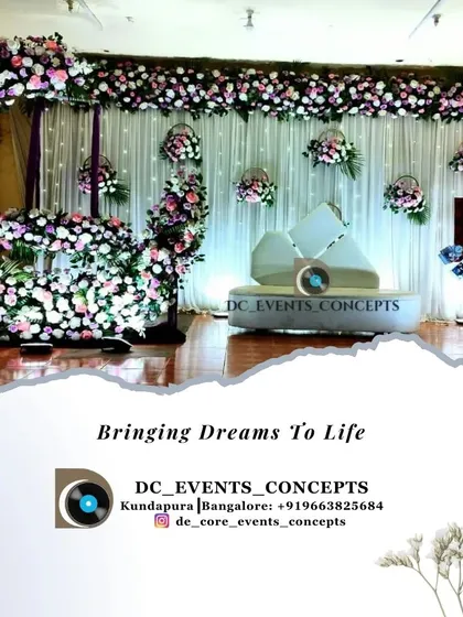 An elegant and dreamy cradling ceremony featuring a crescent moon floral arch. The delicate arrangement of white and lavender flowers against a soft white drape creates a serene and beautiful setting to welcome a new life.