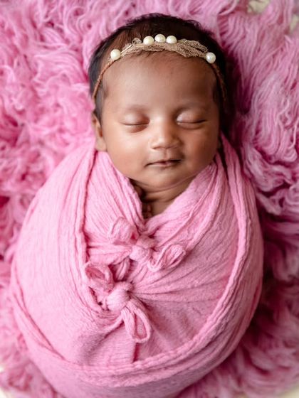 A vibrant pink wrap on a matching fluffy rug. This portrait shows how to use a single color to create a bold and beautiful image.