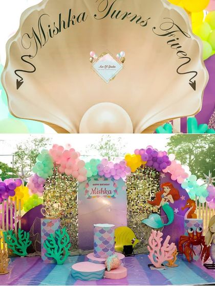 A stunning mermaid-themed backdrop featuring a giant clamshell and characters from under the sea. This setup served as the perfect photo corner and centerpiece for the party.