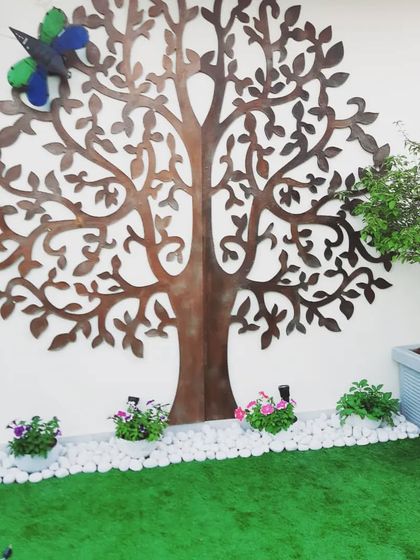 A beautiful laser-cut metal tree of life wall art, creating a stunning focal point on this terrace.