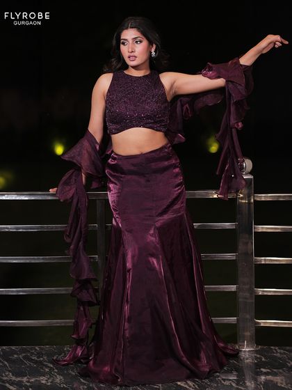 A full-length shot of the purple lehenga against a night-time backdrop. This is the perfect glamorous outfit for a cocktail party or reception.