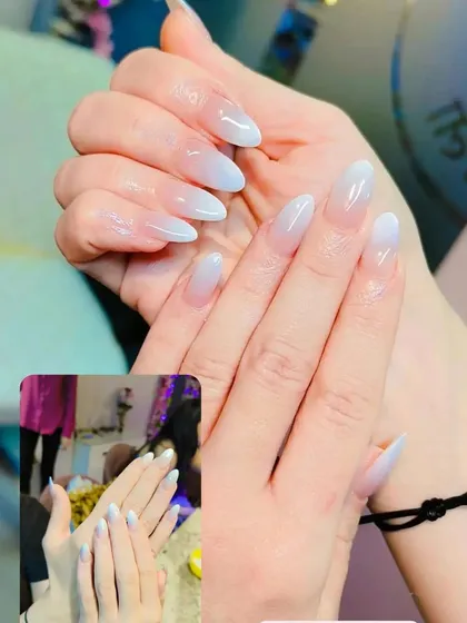 A beautiful example of the timeless baby boomer or American manicure. The soft, milky white ombre on almond-shaped nails provides a clean, natural, and sophisticated look.
