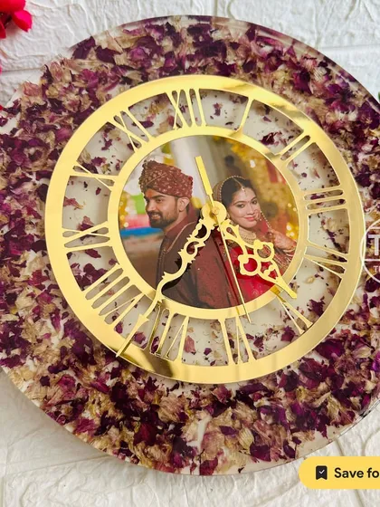 A 12-inch resin wall clock with a central photo, surrounded by preserved purple and white flower petals. The golden dial adds a touch of elegance.