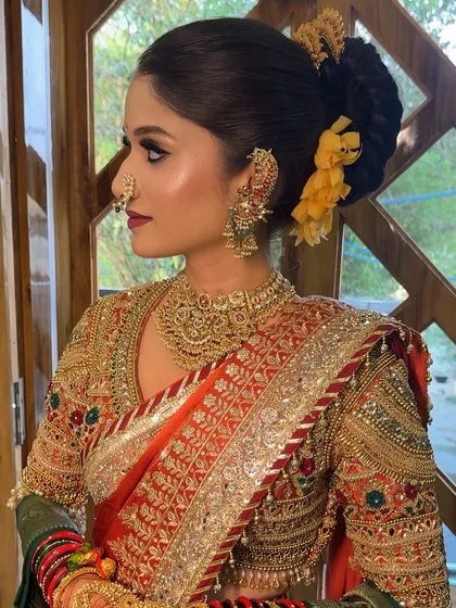 A side profile of the bride, highlighting her floral bun and winged eyeliner.