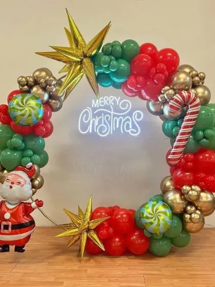 For a corporate Christmas party, I created this festive circular balloon wreath using red, green, and gold balloons. The setup includes a "Merry Christmas" neon sign, candy cane and star-shaped foil balloons, and a cheerful Santa Claus figure.