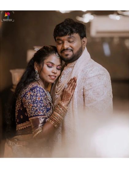 A soft and dreamy reception portrait, capturing the bride resting her head on the groom's shoulder. The gentle lighting enhances the romantic and intimate feel of the moment.