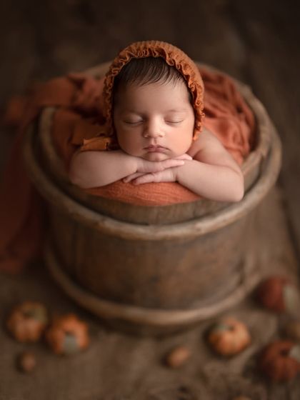Our little pumpkin. My husband and I worked together to create this autumn-themed shot for our son Caden, with a rustic bucket and tiny pumpkins.
