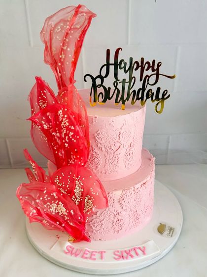 Celebrating a "Sweet Sixty" with this dramatic two-tier pink cake. The textured frosting and bold, handcrafted sugar sails make a stylish statement.