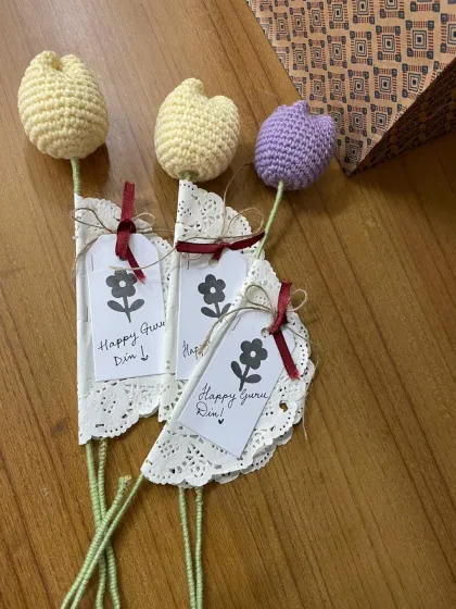 A closer look at the yellow and purple crochet tulips for Teacher's Day, showing the handwritten notes and delicate wrapping.