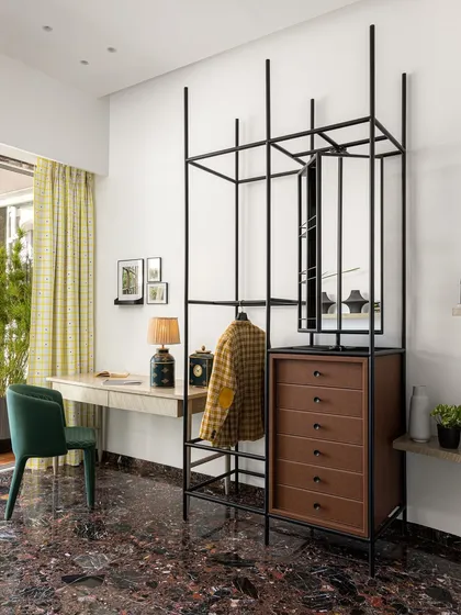 This open-frame wardrobe and study unit in a 6BHK Mumbai residence is a perfect example of multi-functional design. It provides storage, a workspace, and a strong graphic element to the room, all while feeling light and airy.