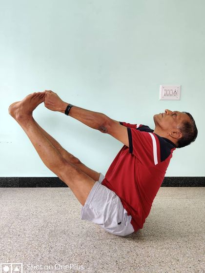 Urdhva Mukha Paschimottanasana. A challenging variation of boat pose that deeply stretches the hamstrings while testing core strength and balance.