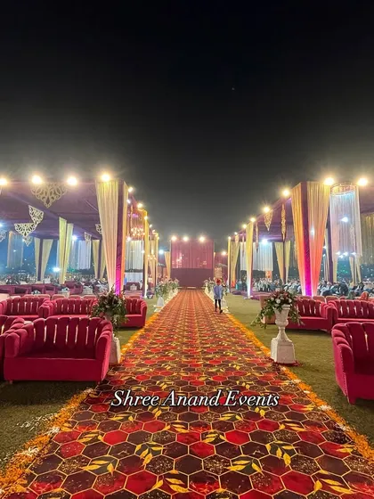 A long, patterned carpet runner flanked by plush pink sofas creates a luxurious and comfortable pathway for guests.
