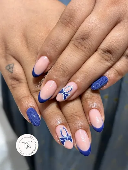 A complete look at this winter-themed set, combining blue French tips, hand-painted bows, and 3D sweater-textured accent nails.