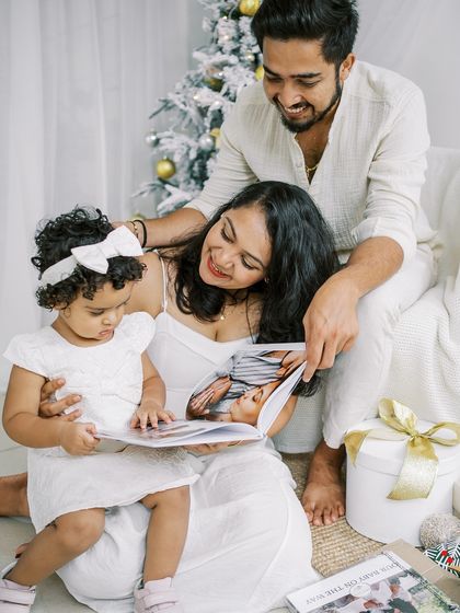 A family looking at a photo album from a previous session. It was a real gift during this Christmas mini, and their joy was wonderful to capture.
