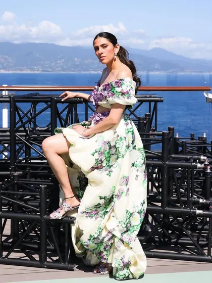 A powerful pose in the Yara Shoemaker gown, highlighting the high-low skirt and the intricate floral details on the bodice.