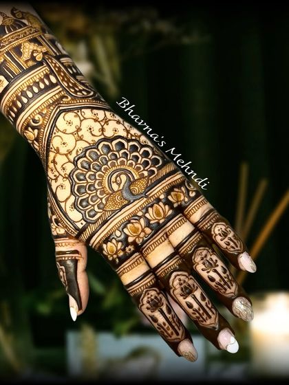 A stunning back-hand design featuring a central peacock mandala and architectural elements on the wrist.