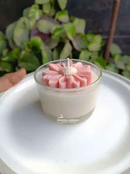 The pink flower jar candle on a white plate.