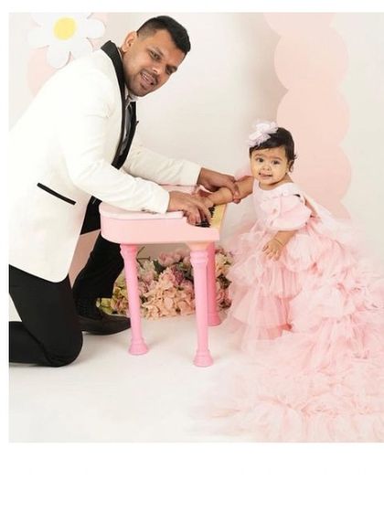 A daughter's first love and her first big party. This little princess is celebrating in a custom pink ruffled gown with a long, elegant trail, creating a beautiful memory with her dad.