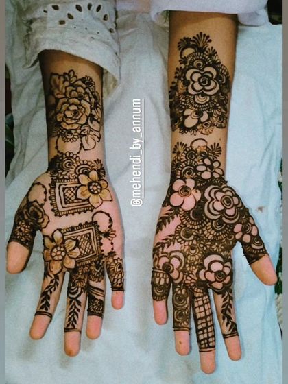 Two hands, two complementary designs for a client. One hand features bold, spaced-out florals while the other has a denser, more traditional pattern, creating a unique and balanced look.