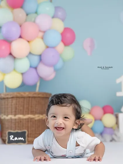 Six months old and flying high! This adorable baby boy is all smiles during his half-birthday photoshoot with our popular hot air balloon theme.