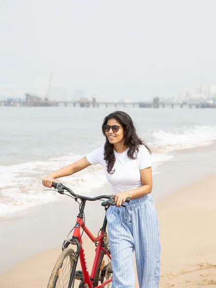 A simple, happy moment on the beach with a bicycle. This image is perfect for a lifestyle brand, as it feels relaxed, summery, and authentic, showcasing casual wear in an aspirational setting.