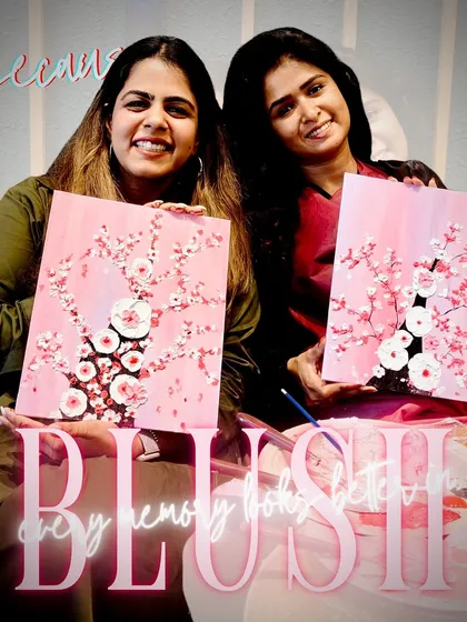 Every memory looks better in blush. Two friends showing off their finished textured cherry blossom canvases, each with its own unique flair.