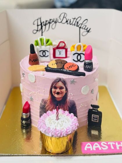 A fun makeup-themed cake with a photo and a "candle blow away" surprise cupcake.