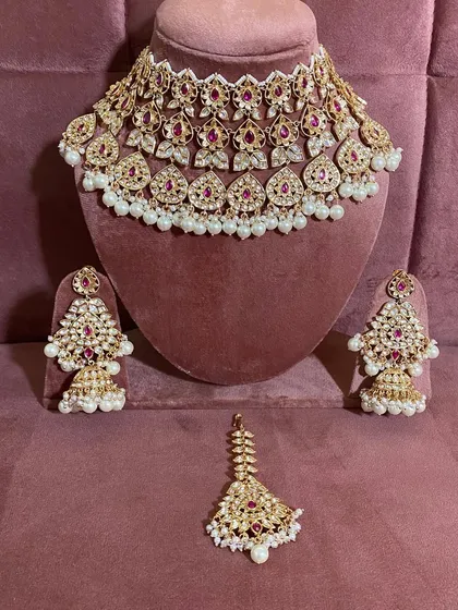 The complete modern ruby choker set, including the necklace, earrings, and maang tikka. This is a popular rental for receptions.