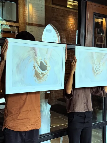 Faces, expressions, moments. Team members holding up artwork, a playful moment at The Loft.