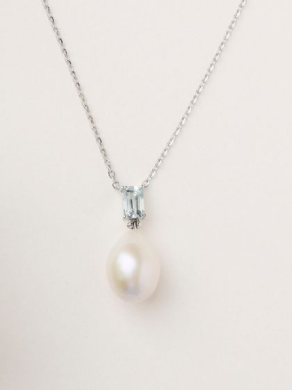 A close-up of the Blue Topaz and Pearl pendant necklace. The combination of the cool blue topaz and lustrous South Sea pearl is effortlessly elegant.