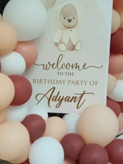 A close-up of the welcome sign for the teddy bear-themed party, showing the cute graphics and personalized text.