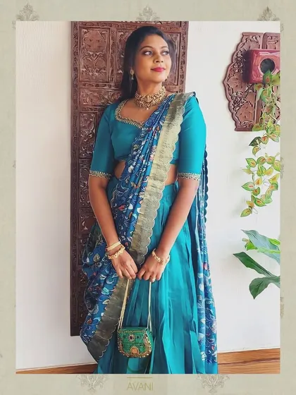 A full view of the client in her teal half-saree. The combination of the plain skirt, simple blouse, and printed dupatta creates a balanced and stylish look.