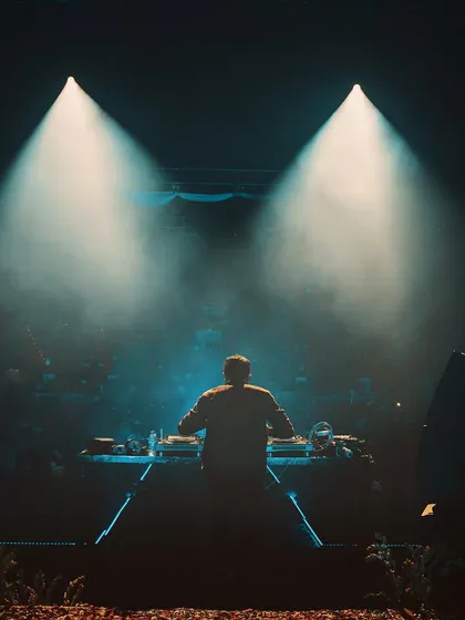 A powerful shot from behind the console, with two spotlights creating a dramatic effect. This captures the solitary focus required to command a massive stage.