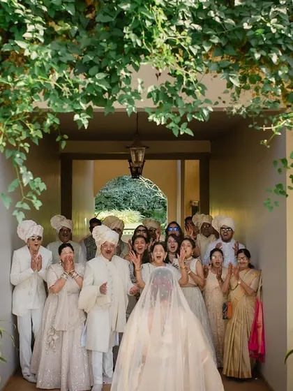 The bride's family and friends reacting with joy and emotion during the first look. Capturing the reactions of loved ones is just as important as the couple's.