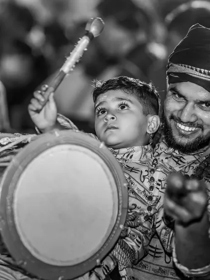 The same heartwarming father-son moment in timeless black and white, focusing on their shared expression of joy and concentration.