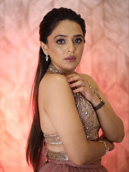 A powerful and confident pose. The makeup enhances her features and gives her a glamorous, red-carpet-ready look.