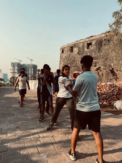 An instructor provides personalized feedback during a pad work drill at our community training event. This hands-on coaching ensures that every participant, regardless of age or skill level, learns the correct technique.
