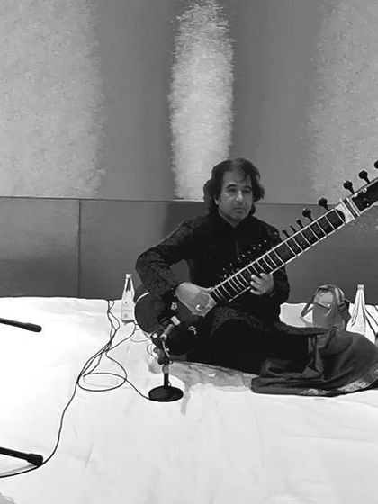 A black and white photo of a performance with Ustad Rafique Khan saheb and Shri Sarfaraaz Khan.