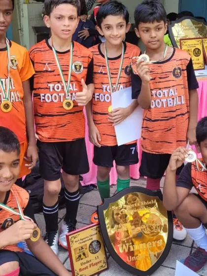 The U11 champions from the 5v5 Sports tournament, showcasing their winners' shield and individual awards.