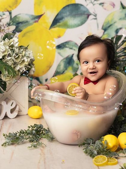 When life gives you lemons, have a milk bath! This little one is enjoying a slice of lemon in his warm, bubbly tub, creating a zesty and adorable photo opportunity.