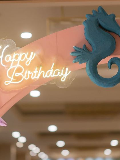 A "Happy Birthday" neon sign adds a modern and celebratory touch. For this baby shark party, it was paired with custom seahorse cutouts to enhance the under-the-sea atmosphere.