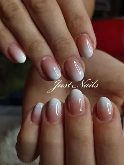 A beautiful and clean pink-to-white ombre on natural, oval-shaped nails.