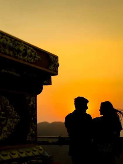 A beautiful silhouette of a couple against a golden sunset, creating a timeless and romantic pre-wedding photograph.