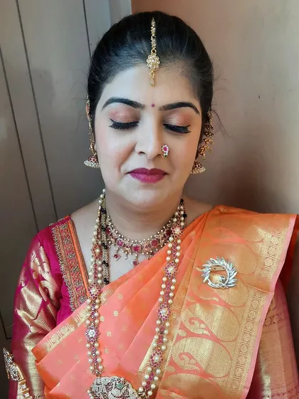 A detailed look at the eye makeup for the housewarming function, featuring soft peach and pink tones with full lashes.