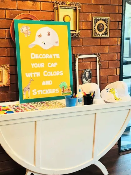 A closer view of the cap decorating station, showing the assortment of stickers and art supplies available for the kids. This highlights a fun, hands-on activity that we can incorporate into our party packages to keep the little ones engaged.