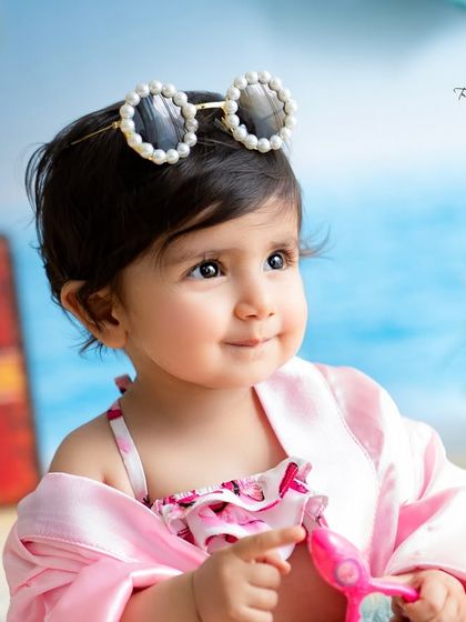 A close-up of our little beachgoer, looking stylish with her pearl sunglasses. I focus on capturing these sweet details and expressions.