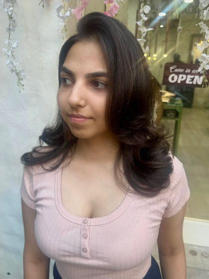 A happy client showing off her new haircut and style. We gave her soft, blended layers and a classic blowout that perfectly frames her face.
