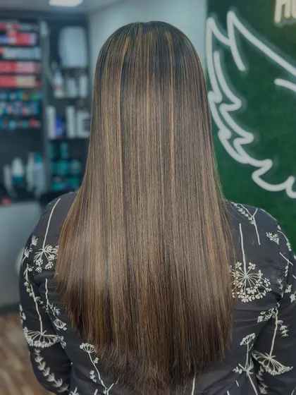 The final result of a sleek highlight service. The hair is smooth, shiny, and features beautifully integrated streaks of color.