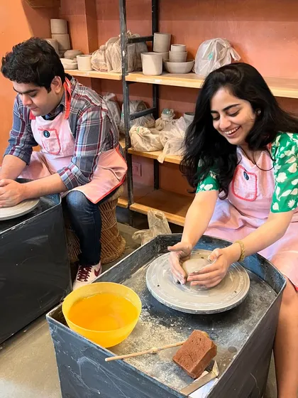 The smiles say it all. A couple enjoying a fun and creative date at the potter's wheel.
